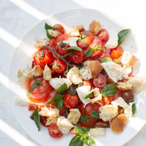 sliced tomato and green leaf vegetable on white ceramic plate